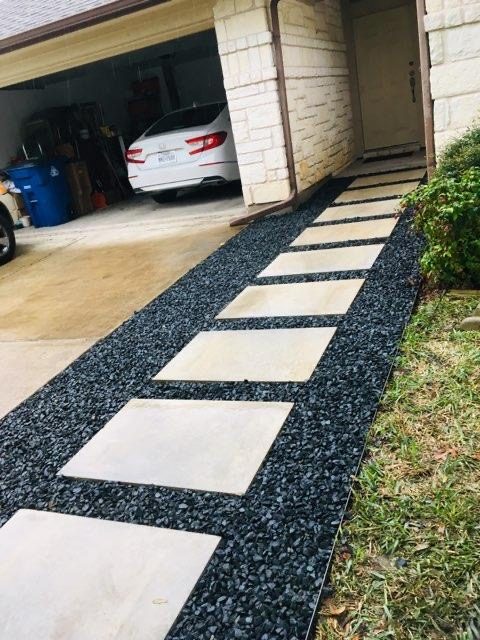 Stepping-stone pavers set in dark gravel to a front door