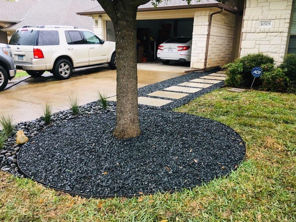 Dark gravel walk with tan pavers and a circular tree bed